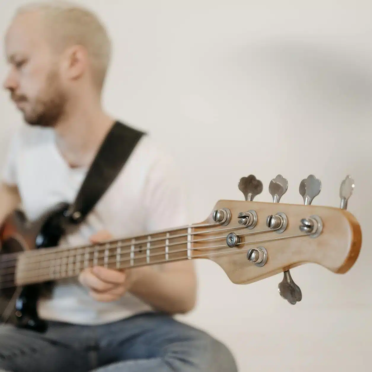 close up shot of a man in white shirt playing guitar