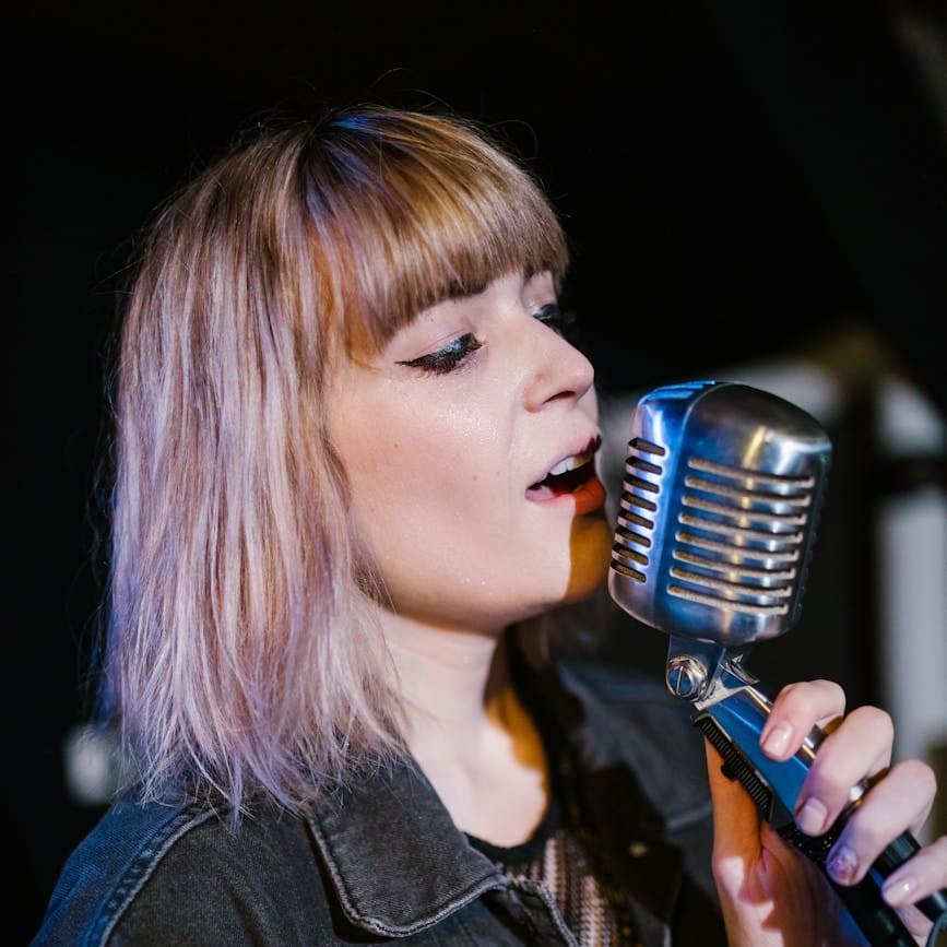 side view of a young woman singing