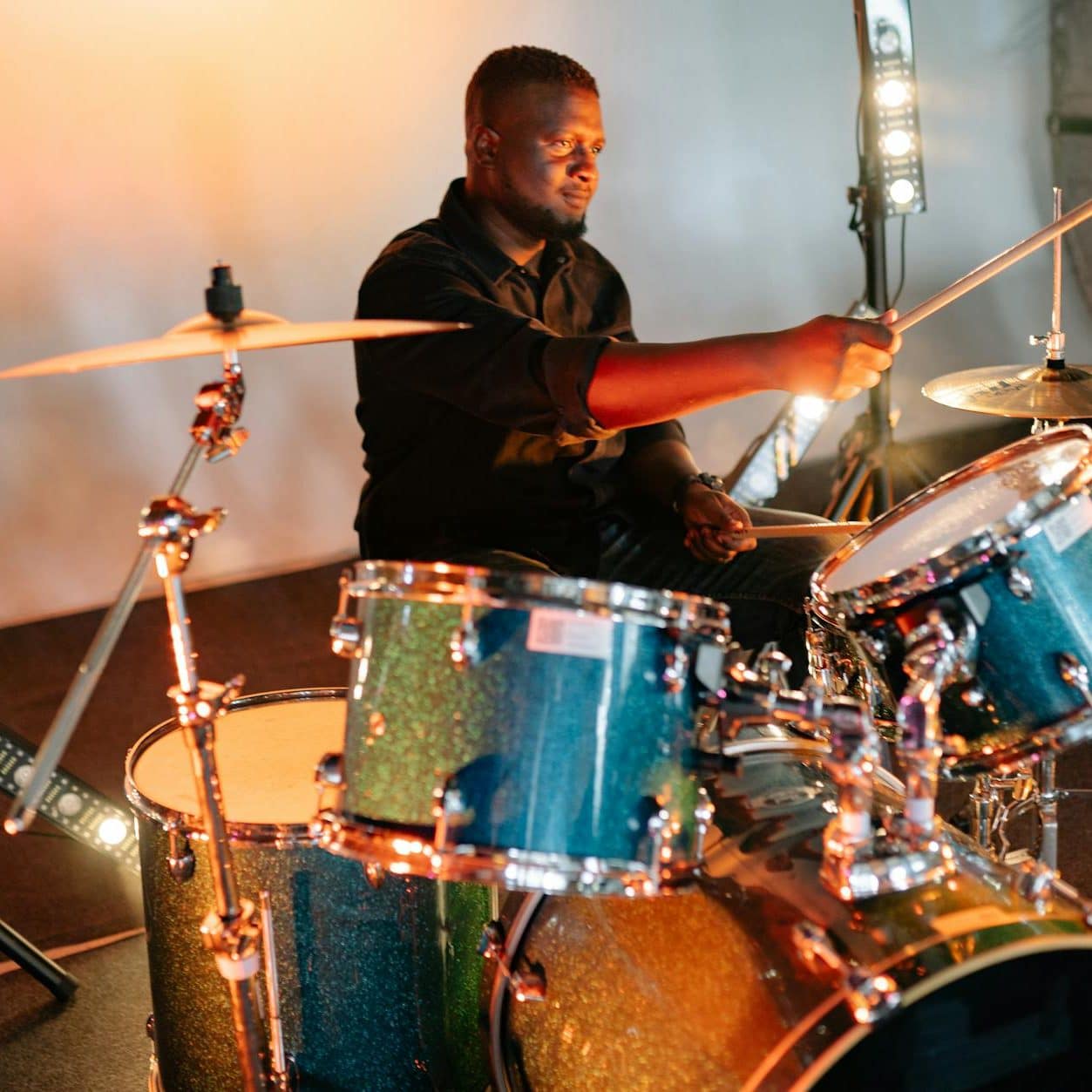 man in black shirt playing drum set